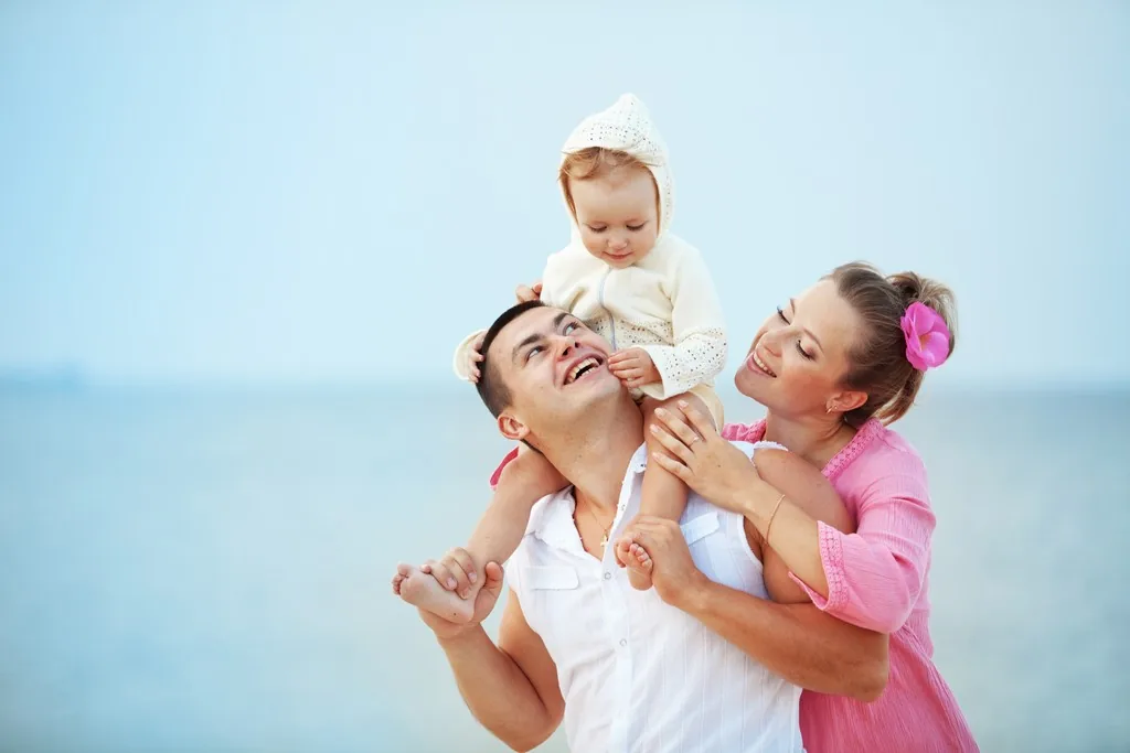 Sahilde çocuklarıyla birlikte vakit geçiren mutlu aile